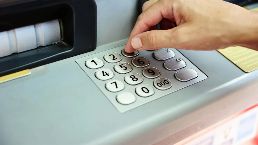 ATM 숫자판에 비밀번호를 누르는 손